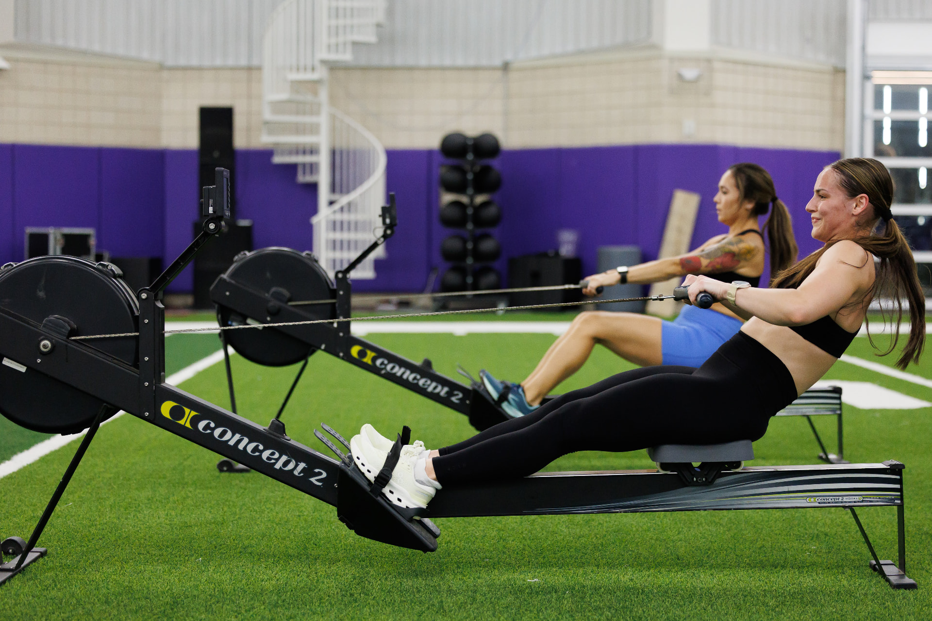 Two athletes rowing on Concept2 ergs during a race